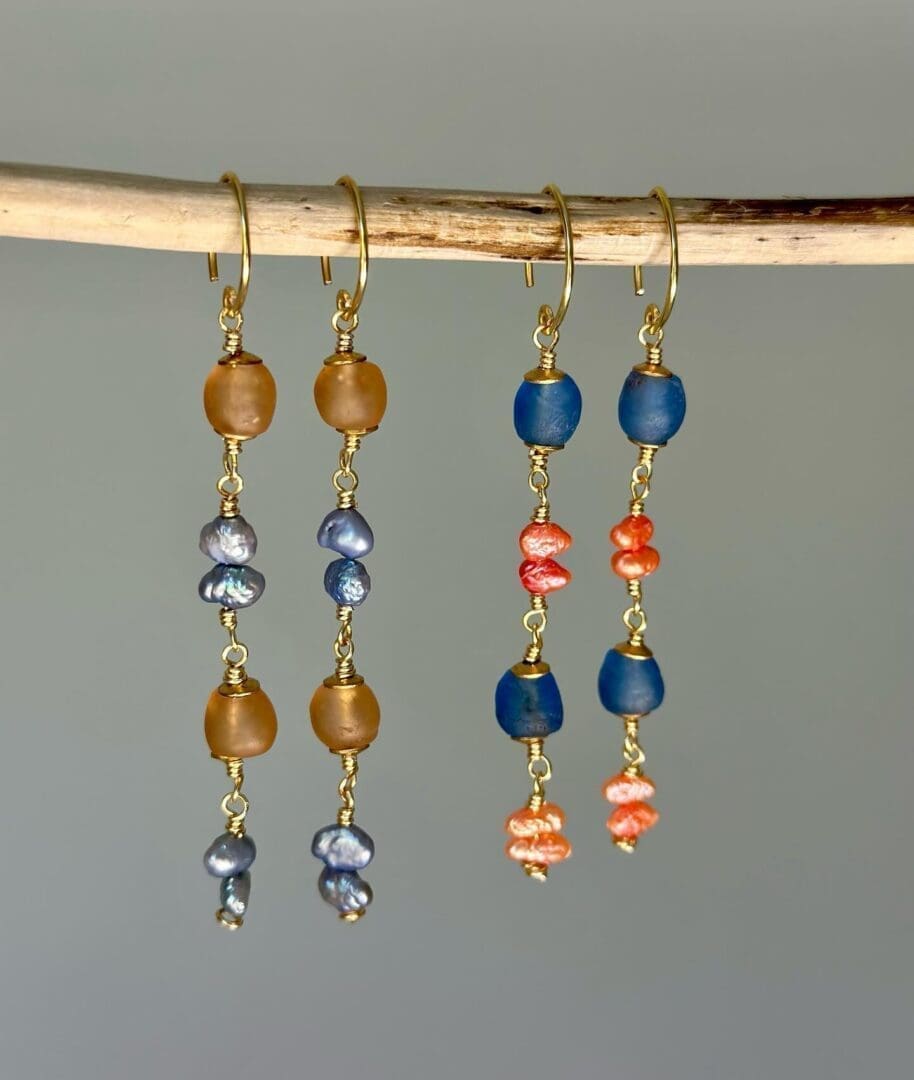 A pair of earrings hanging on a branch.