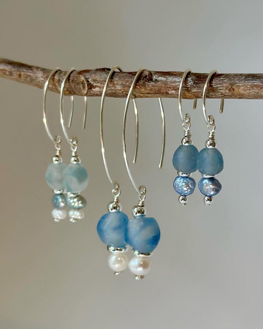 A pair of earrings hanging on a branch.