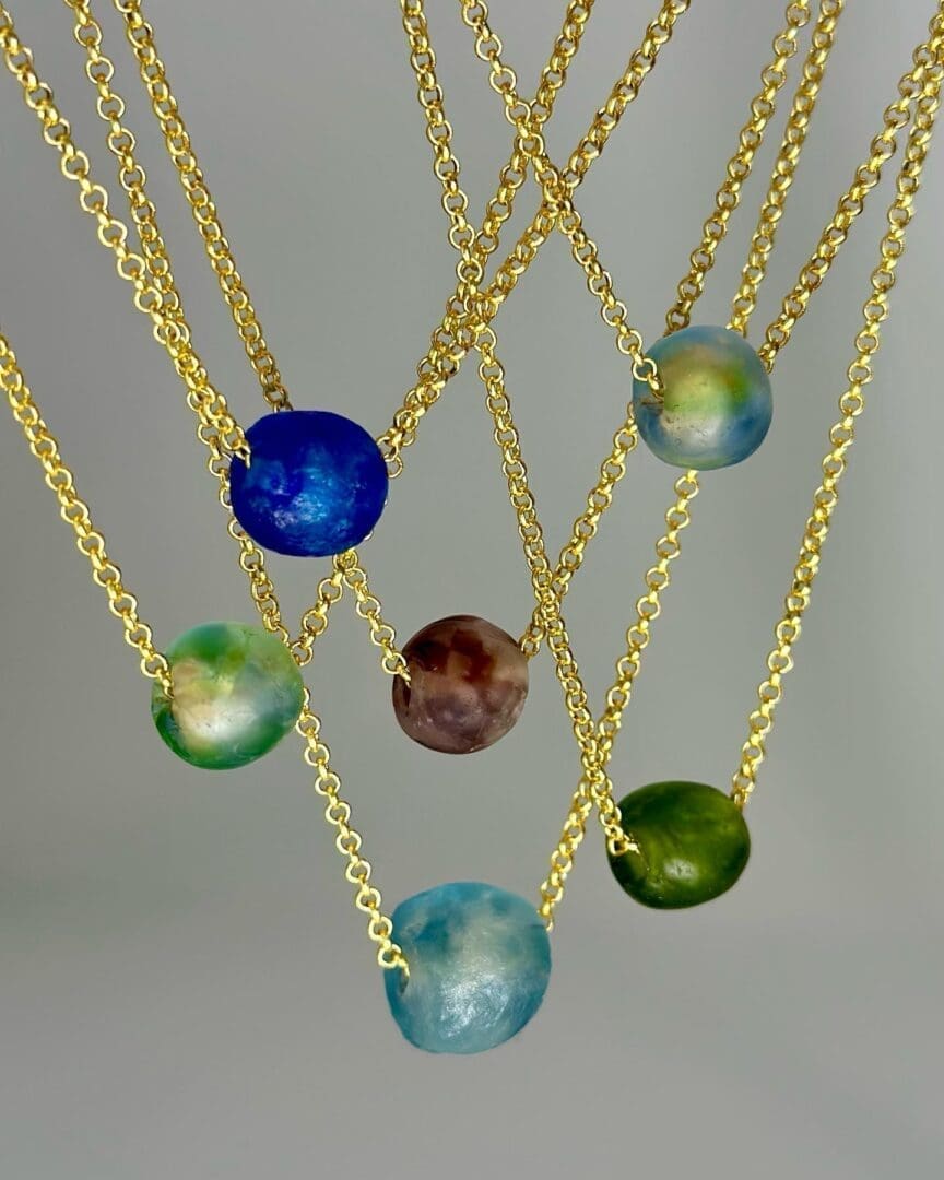 A group of necklaces that are hanging from chains.