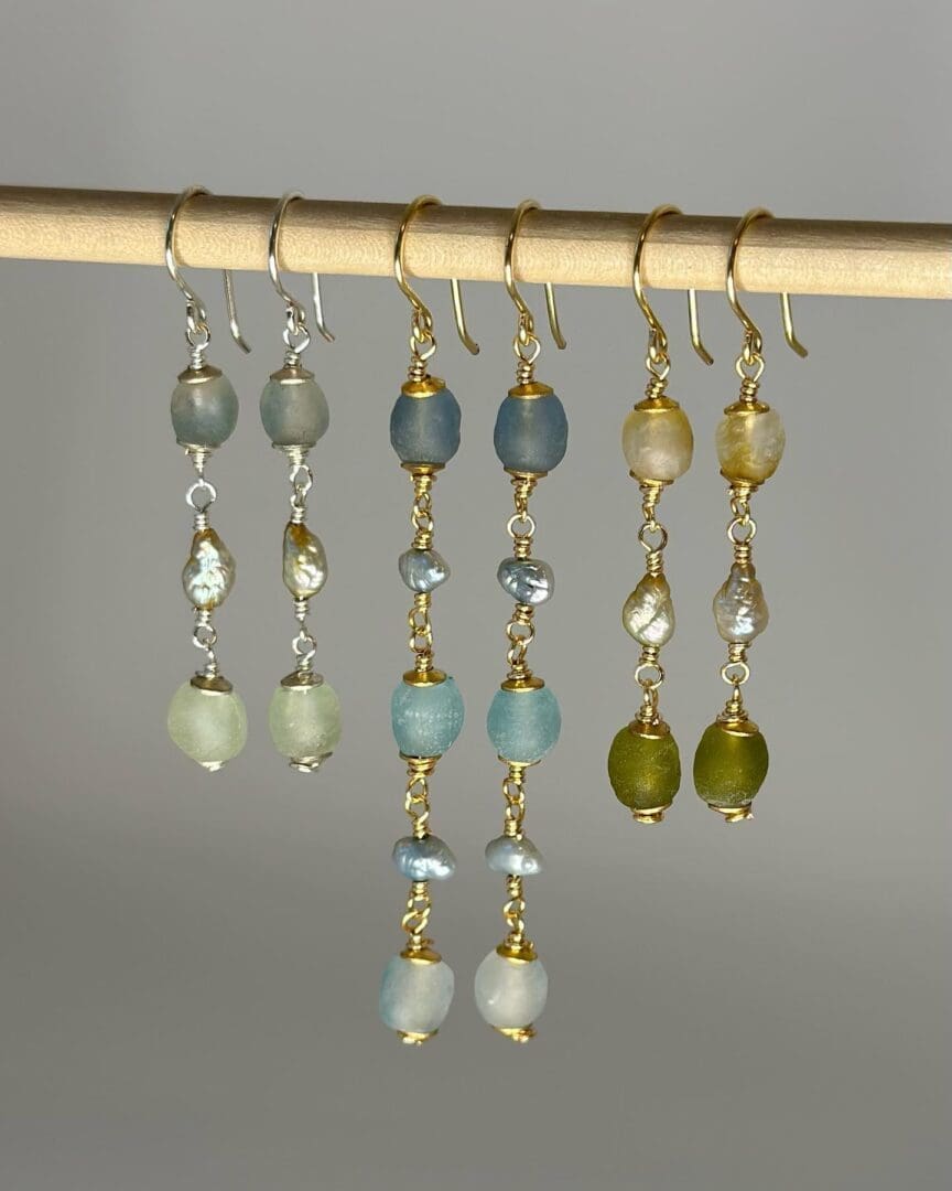 A group of earrings hanging on a rod.