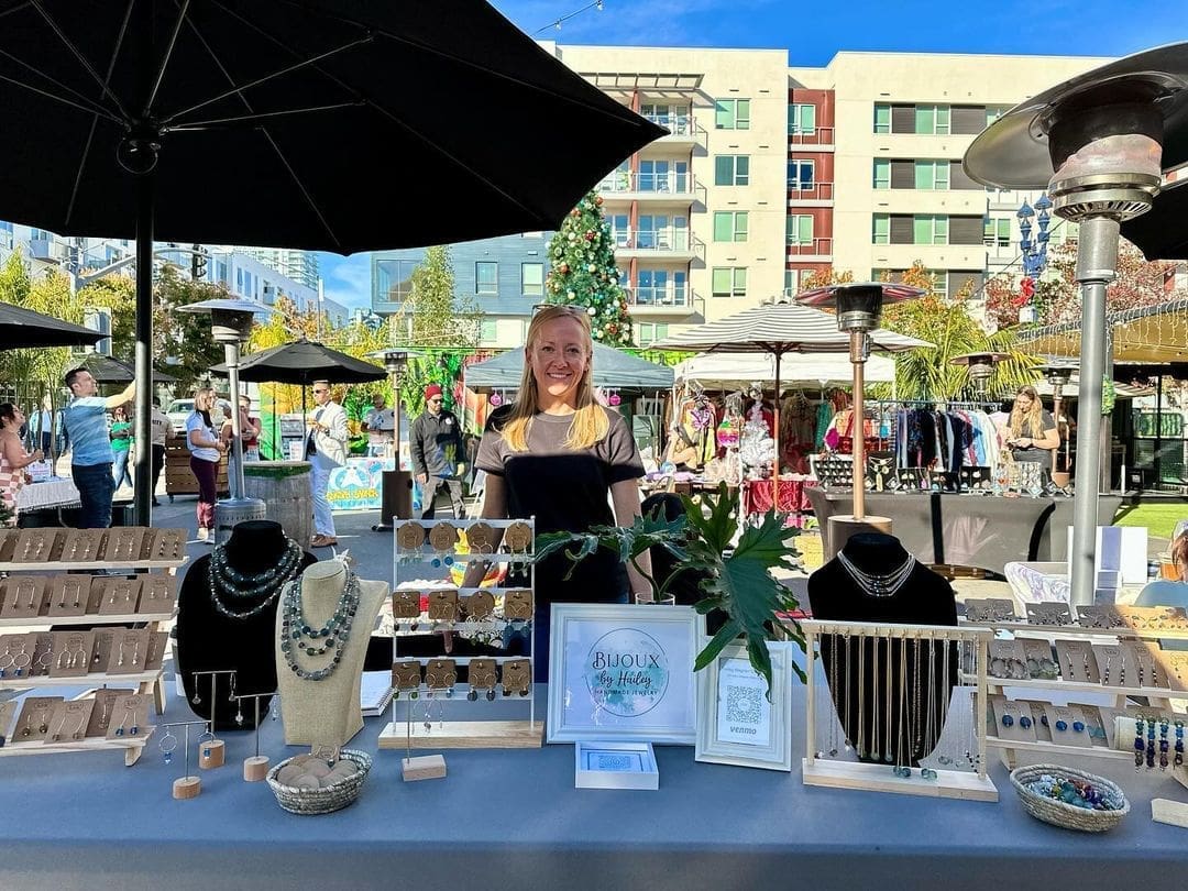 A woman standing in front of several jewelry displays.