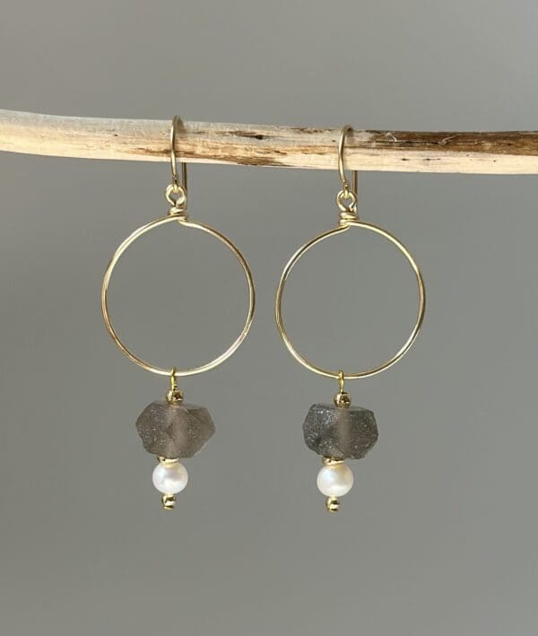 A pair of earrings hanging from a stick.