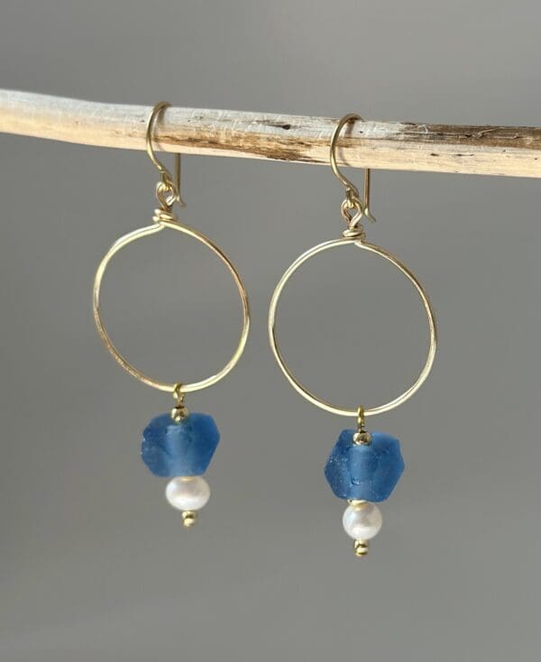 A pair of earrings hanging on a stick.