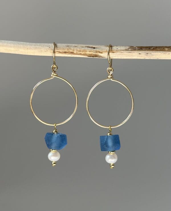 A pair of earrings with blue glass and pearl beads.