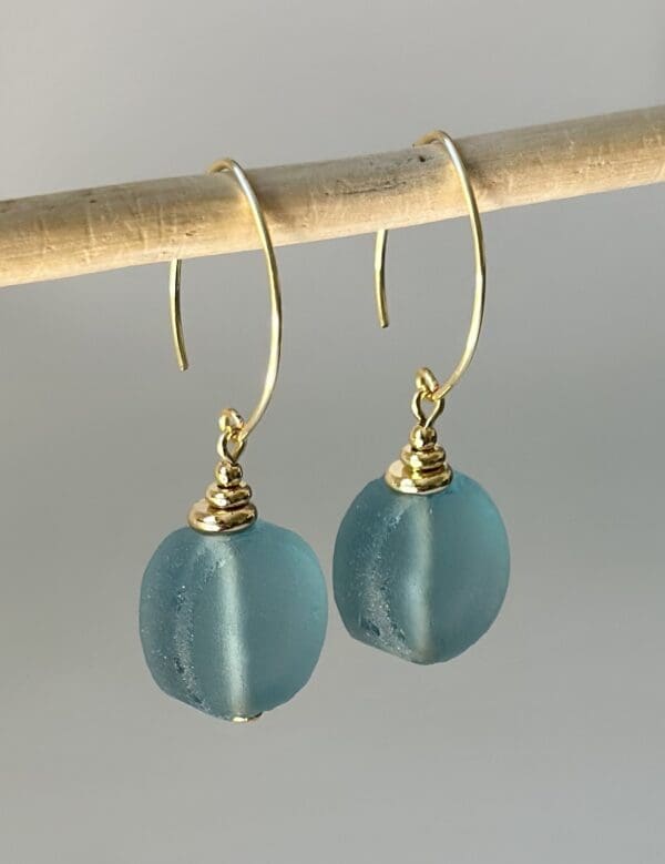 A pair of earrings hanging on a stick.