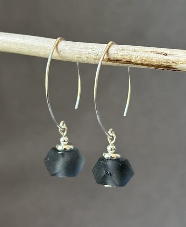 A pair of earrings hanging on a stick.