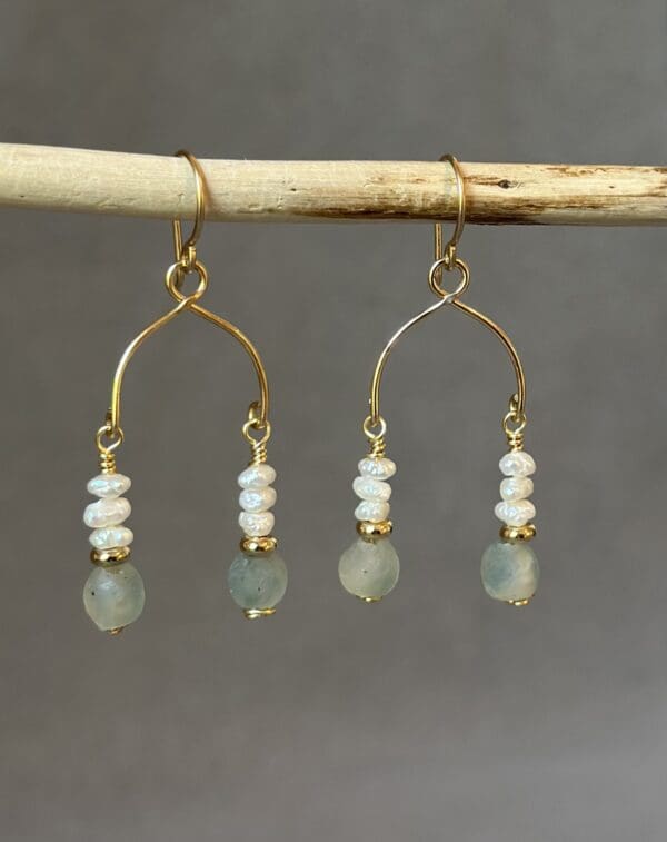 A pair of earrings hanging from a stick.