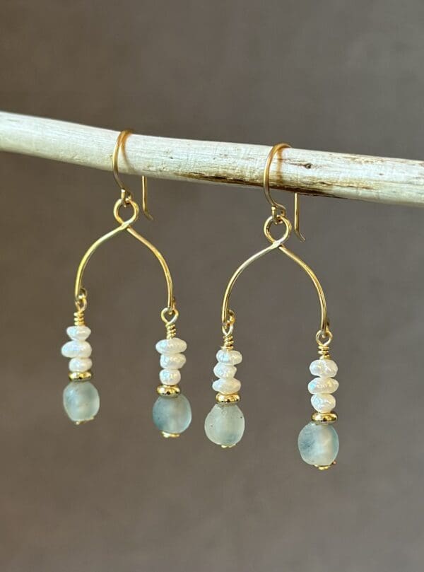 A pair of earrings hanging from a stick.