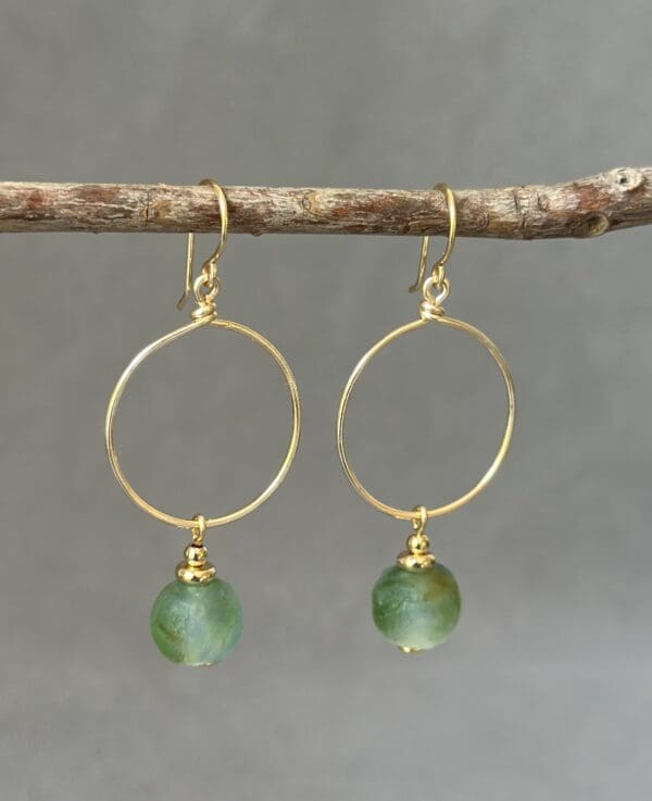 A pair of earrings hanging from a tree branch.