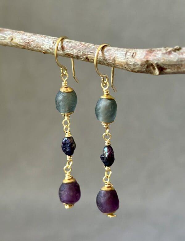 A pair of earrings hanging from a tree branch.