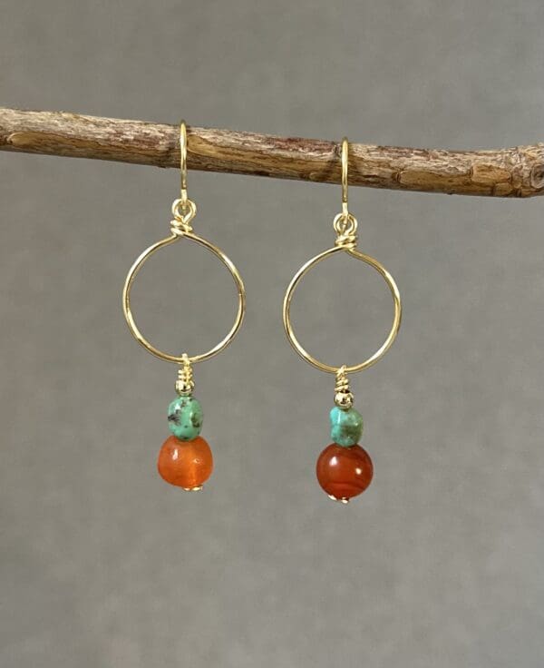 A pair of earrings hanging from a tree branch.