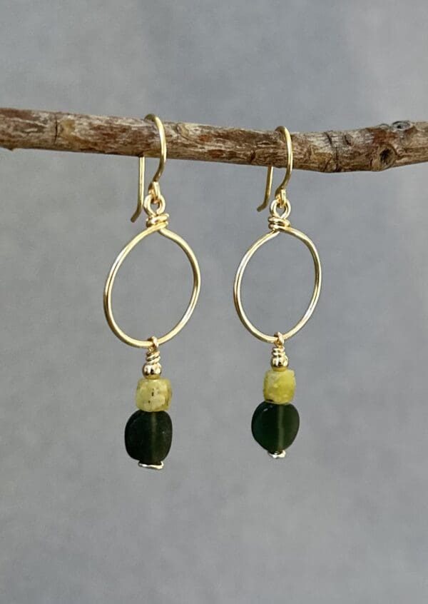 A pair of earrings hanging on a tree branch.