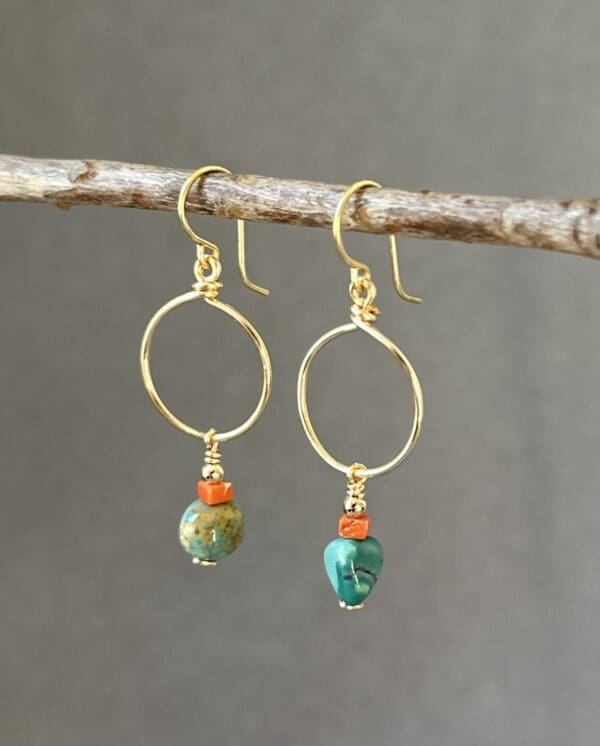 A pair of earrings hanging from a tree branch.