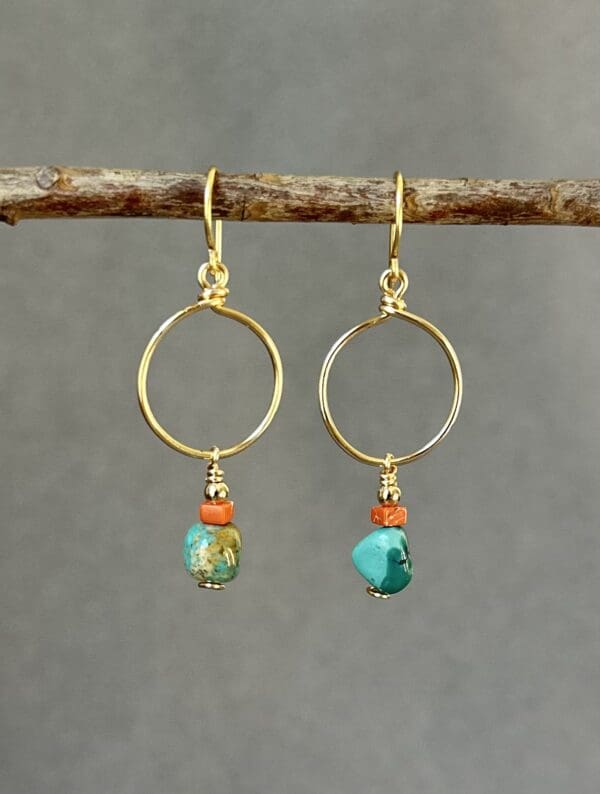 A pair of earrings hanging from a tree branch.