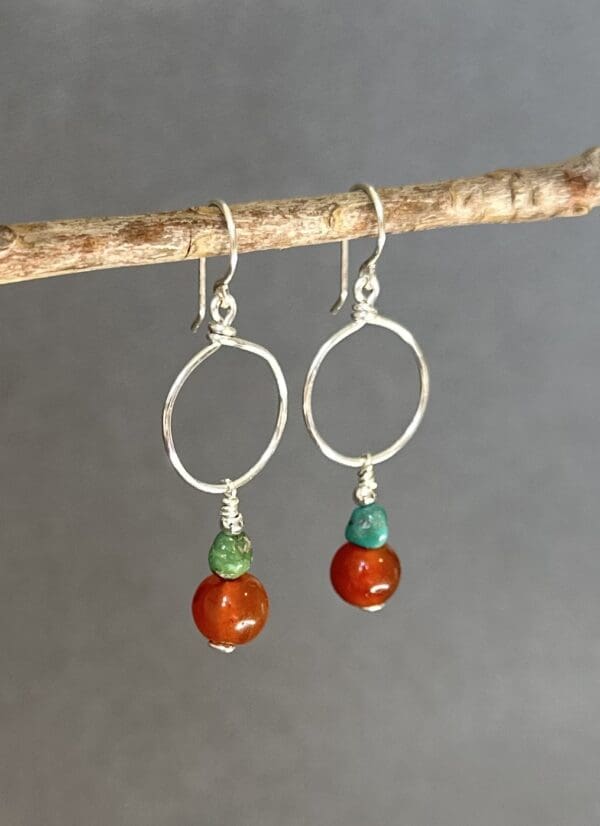 A pair of earrings hanging from a branch.