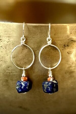 A pair of earrings hanging from the side of a metal wall.