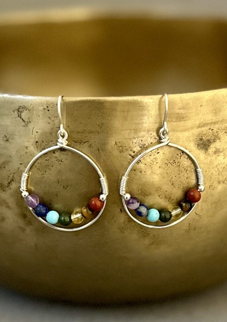 A pair of earrings with different colored beads.