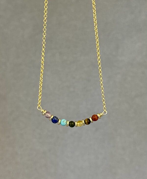 A necklace with seven different colored stones on it.