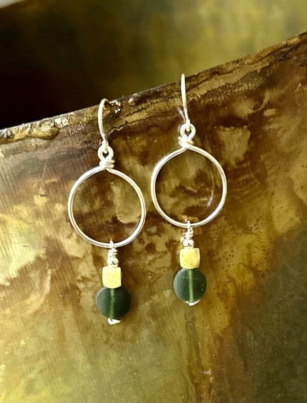 A pair of earrings hanging on top of a wooden table.