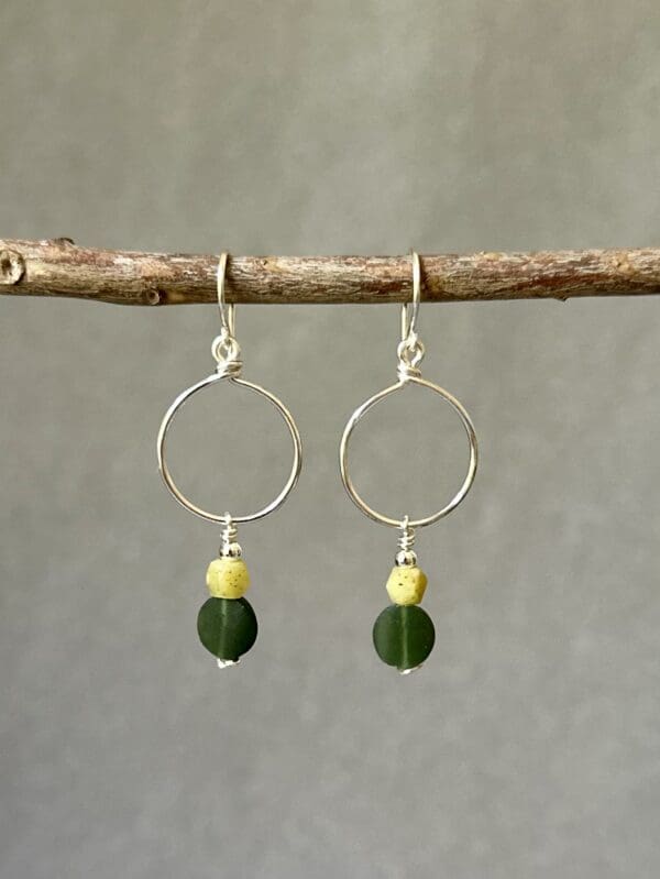 A pair of earrings hanging from a tree branch.