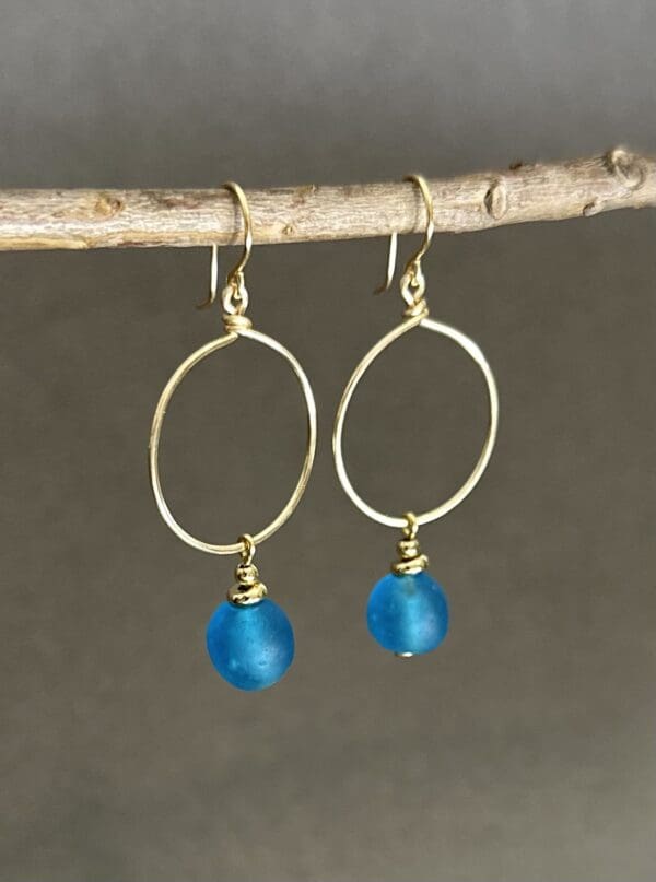 A pair of earrings hanging on a tree branch.