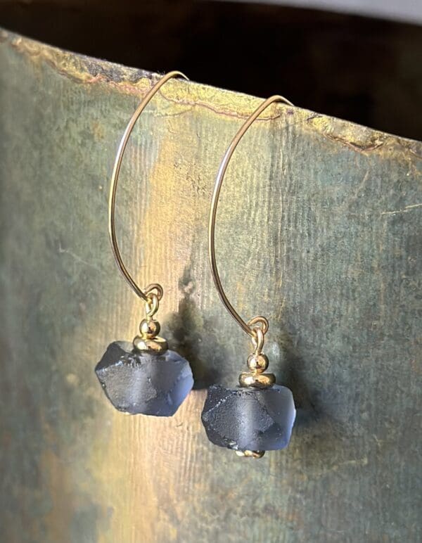 A pair of earrings hanging on top of a wooden table.