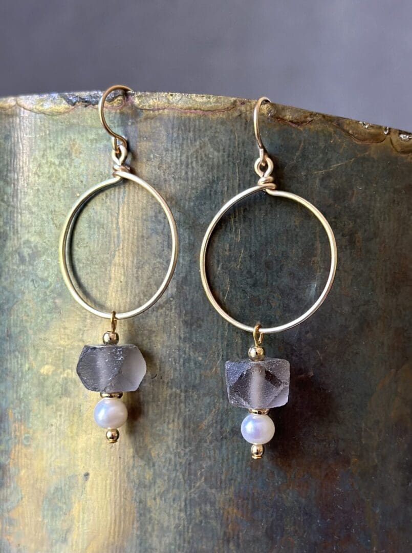 A pair of earrings with glass and pearl beads.