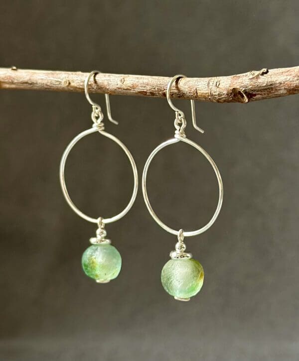 A pair of earrings hanging on top of a tree branch.