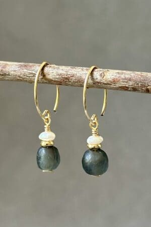 A pair of earrings hanging on a stick.