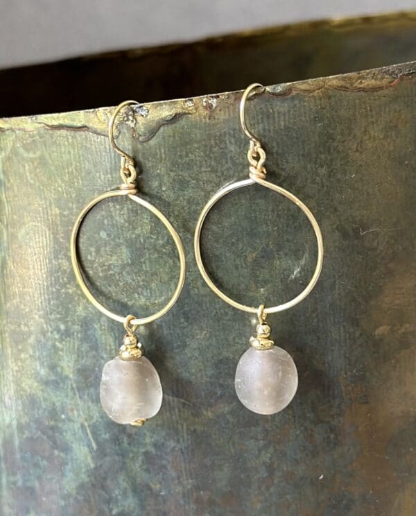 A pair of earrings with a stone on them.