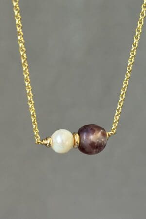 A necklace with two pearls on it