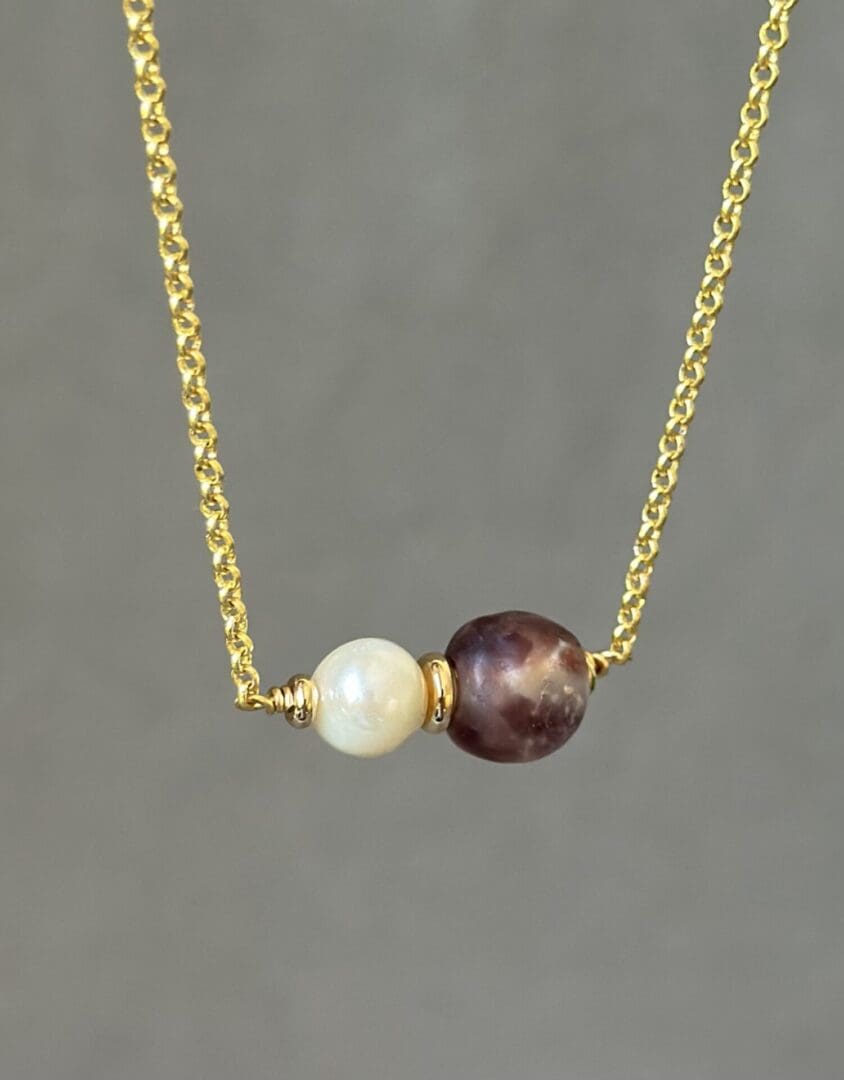 A necklace with two pearls on it