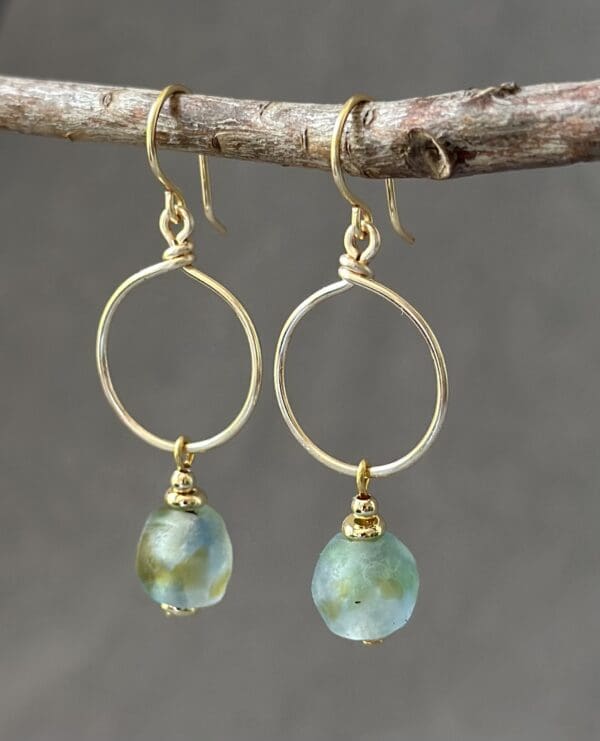 A pair of earrings hanging from a tree branch.