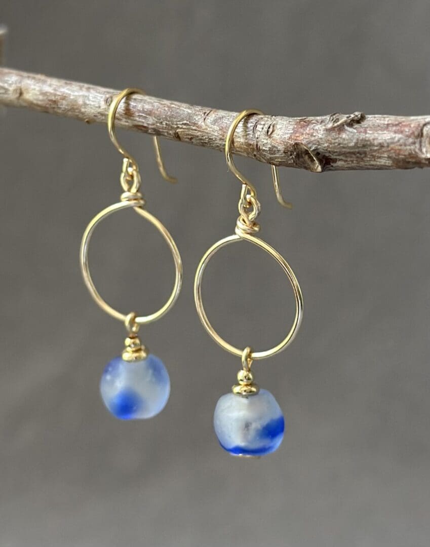 A pair of earrings hanging from a tree branch.