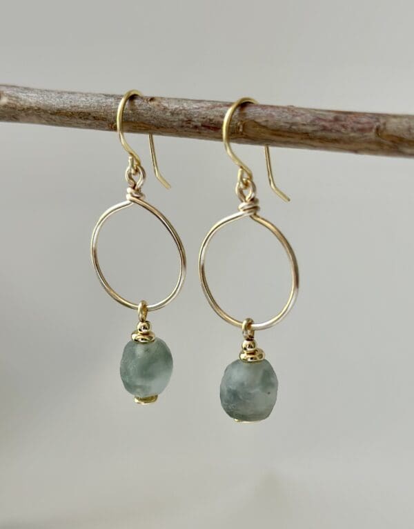 A pair of earrings hanging on top of a tree branch.