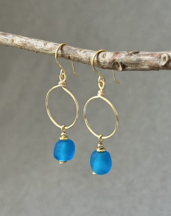 A pair of earrings hanging on a tree branch.