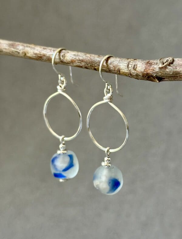 A pair of earrings hanging on top of a tree branch.