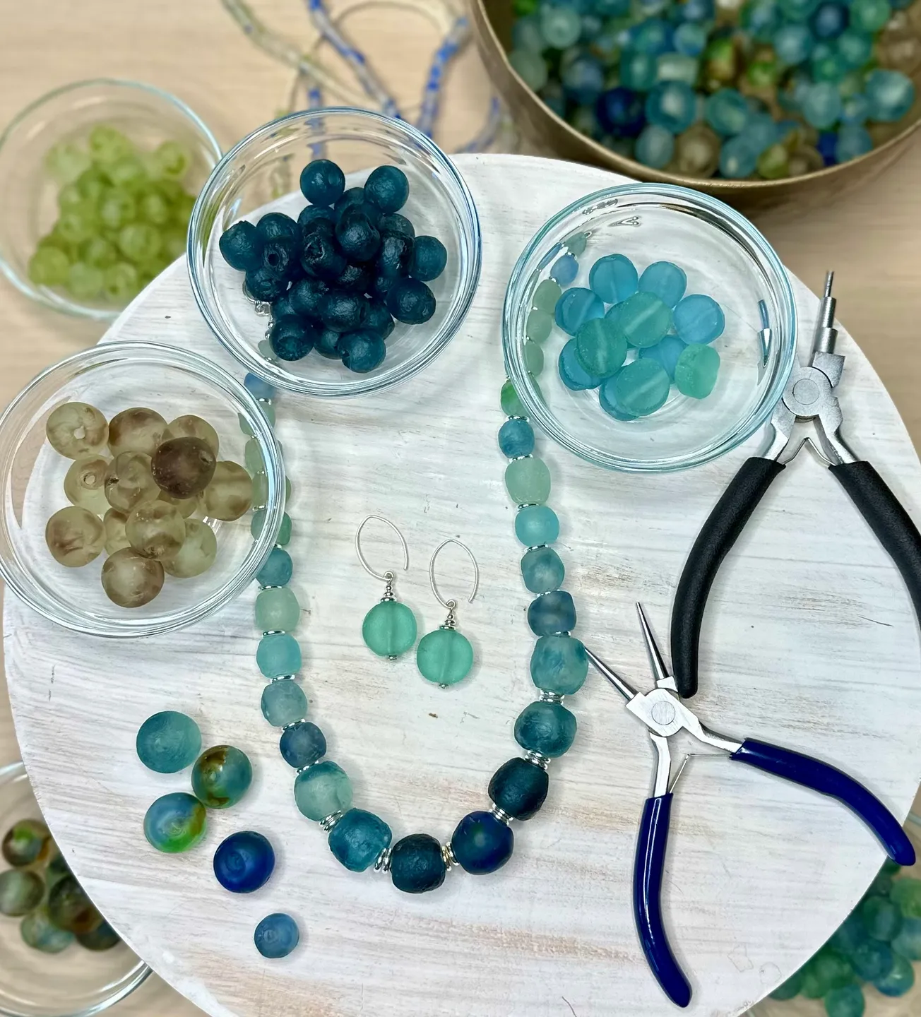 A table with some glass beads and a pair of scissors